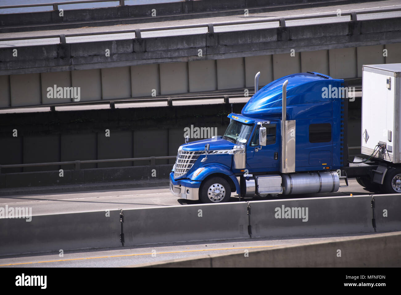 Big rig blue American semi truck transporting commercial cargo in ...