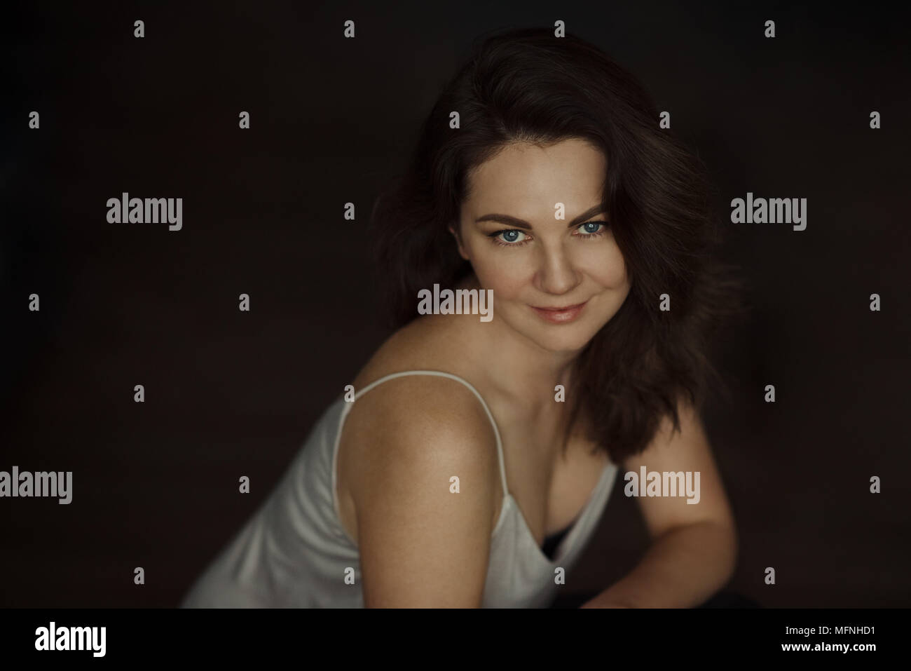 Girl sitting still and looking at camera with open eyes Stock Photo - Alamy