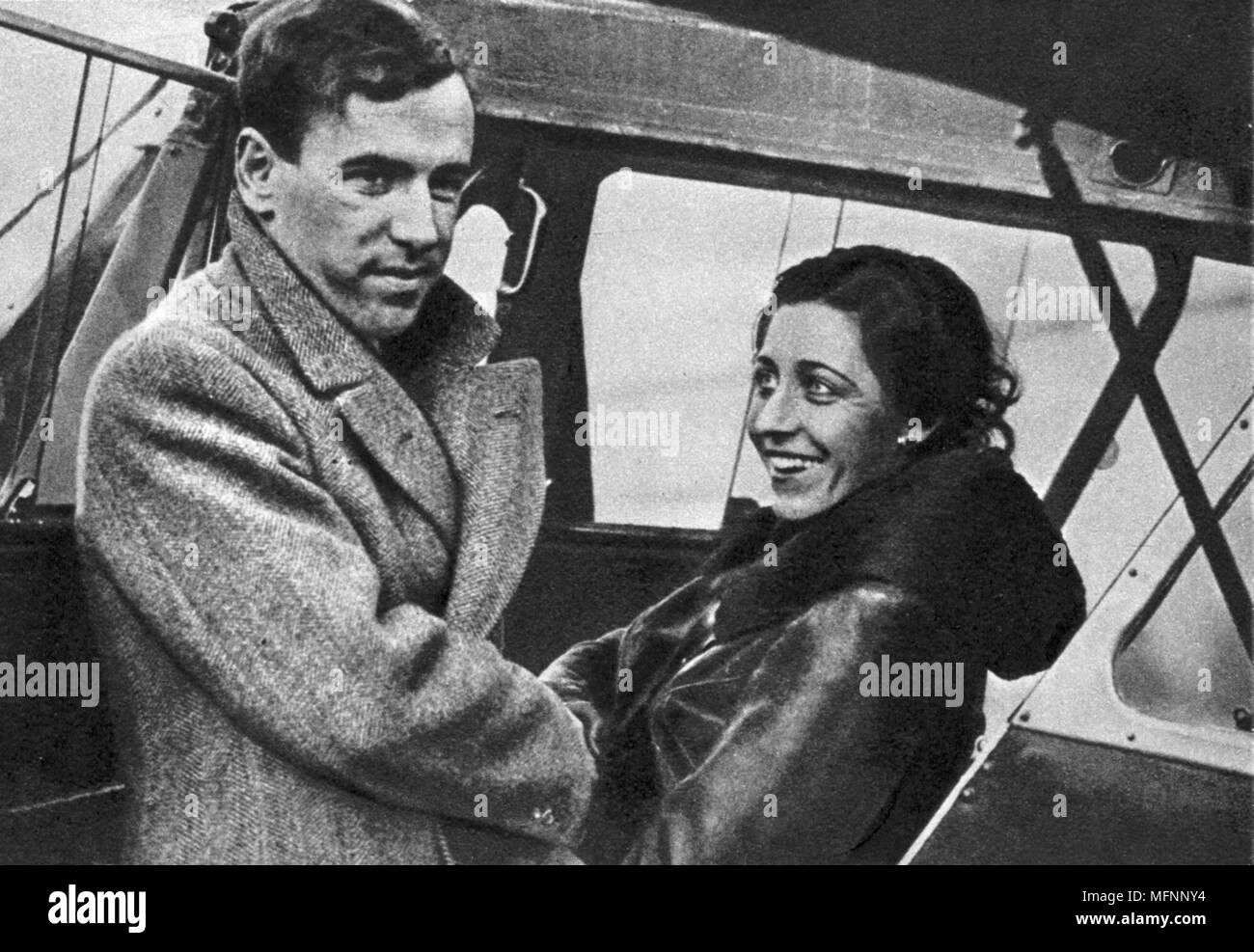 Amy Johnson (1903-1941) English aviator, about to set out for Cape Town 1932. Johnson  saying goodbye to her husband, fellow pilot James Mollison, before starting off.  She created a new record for a solo flight from London to Cape Town, completing the trip in 4 days, 6 hours and 54 minutes, beating her husband's record by 10 hours, 28 minutes. Stock Photo