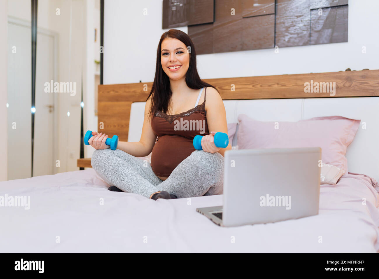Pregnant woman keeping her body fit Stock Photo