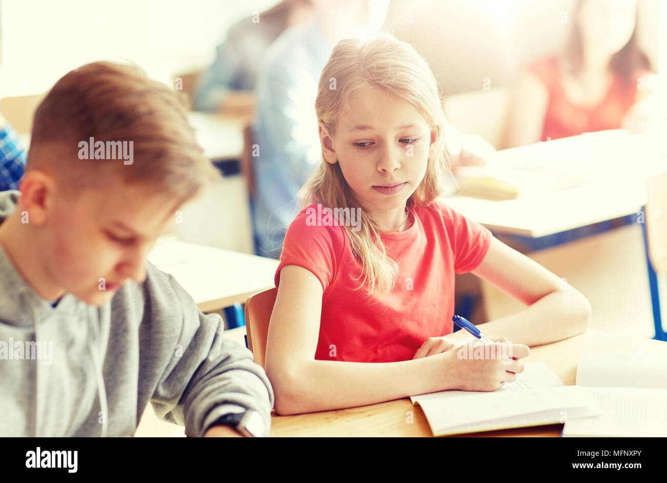 group of students with books writing school test Stock Photo