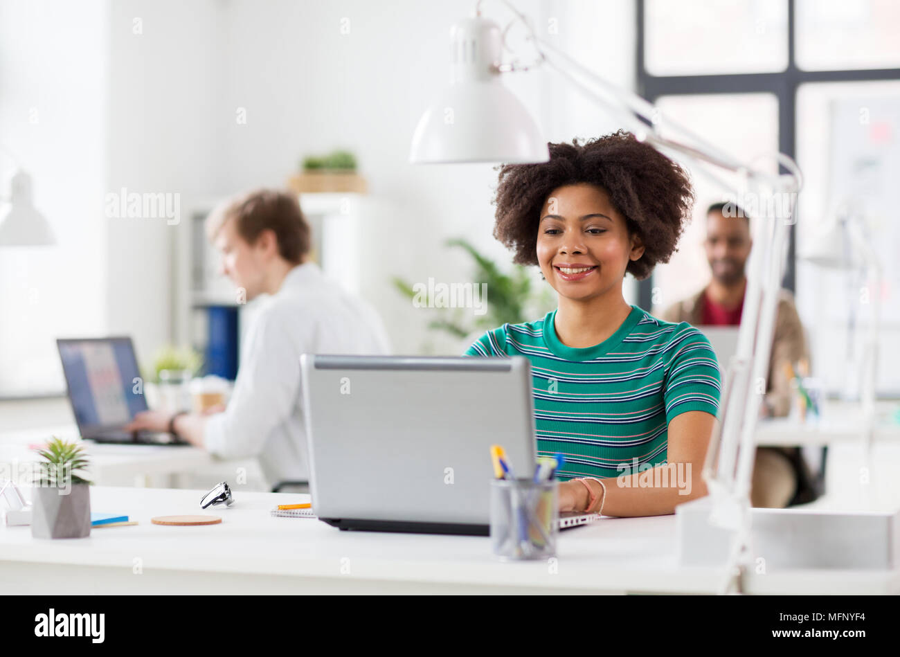 happy african woman with laptop computer at office Stock Photo - Alamy