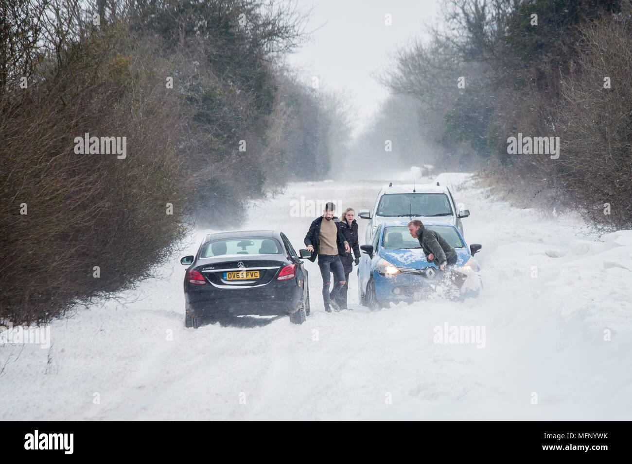 A Man Using A Spade To Dig His Car Out Of A Snow Drift - 