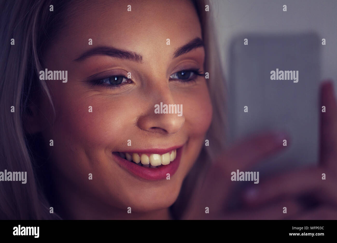 happy smiling young woman with smartphone at night Stock Photo
