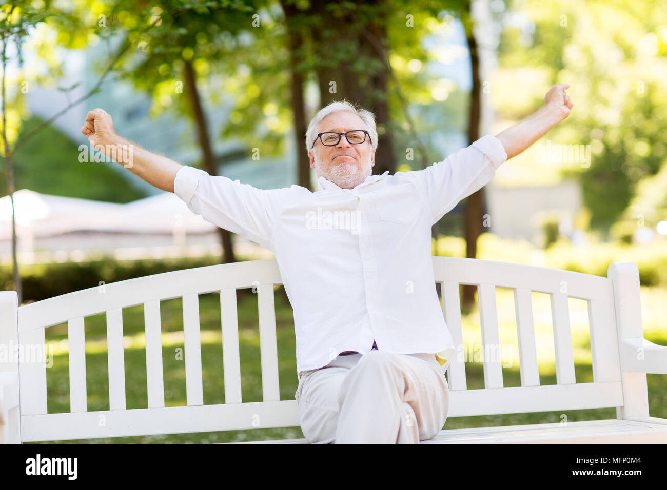 happy senior man in glasses sitting at summer park Stock Photo - Alamy