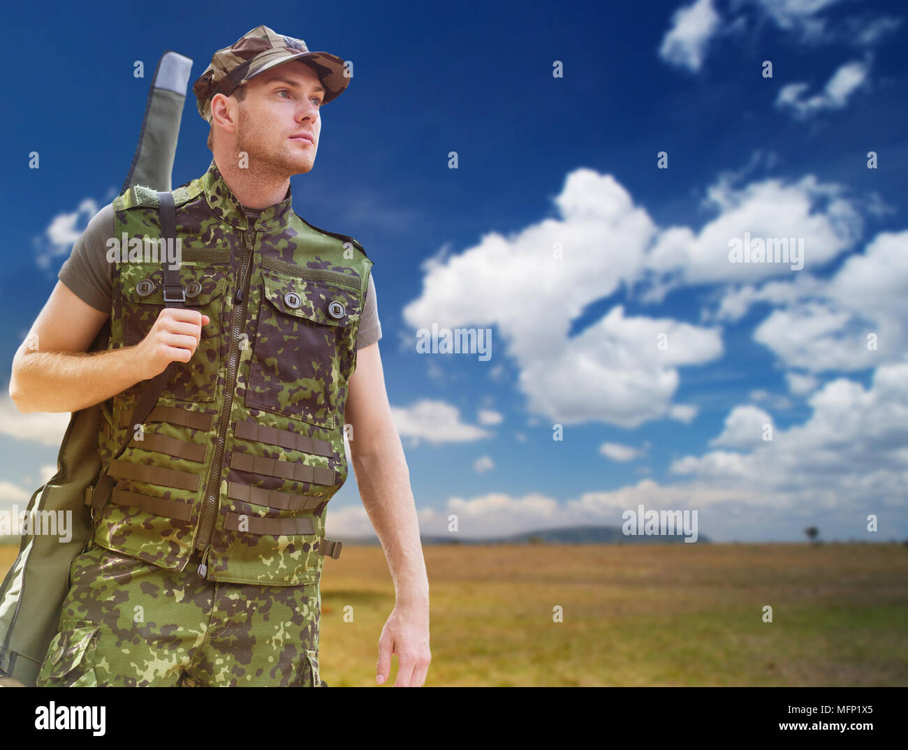 young soldier or hunter with gun over savannah Stock Photo