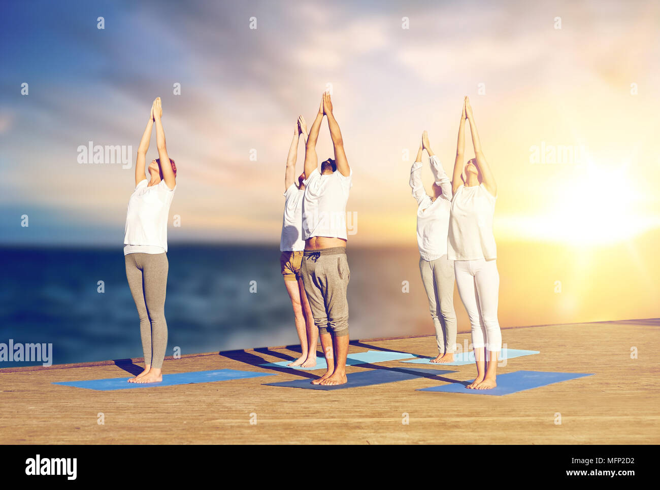 Couple of yogis in urdhva hastasana in bright studio. Young man and woman  practicing upward salute yoga pose. Fitness, athletic, workout, exercise,  pilates ball, props, healthy lifestyle concepts Stock Photo | Adobe