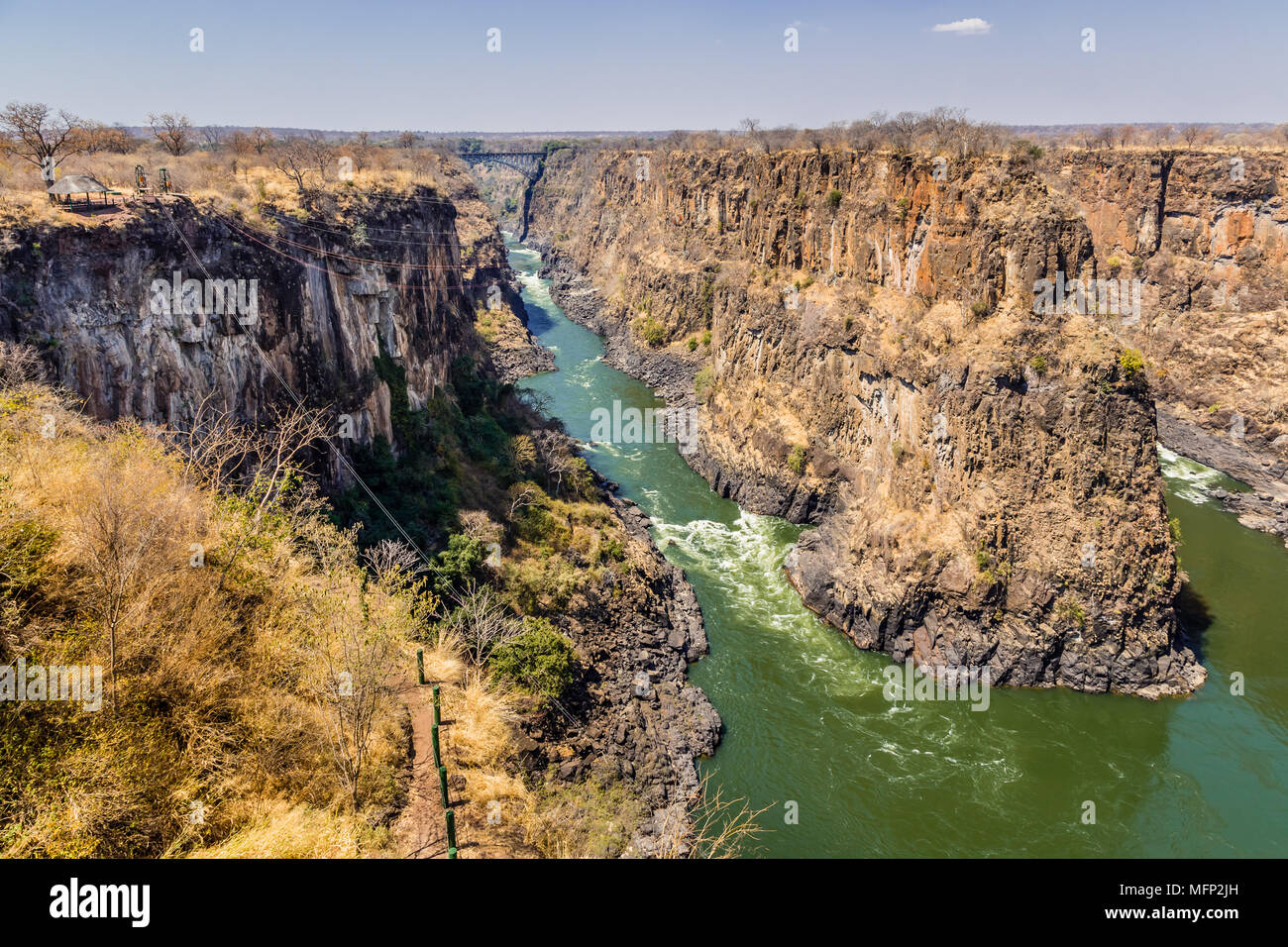 The iconic Victoria Falls Bridge over the Second Gorge in Zimbabwe, with the Gorge Swing to the left. Stock Photo