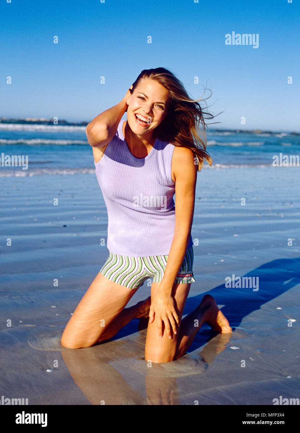 Portrait woman kneeling on beach hi-res stock photography and images ...