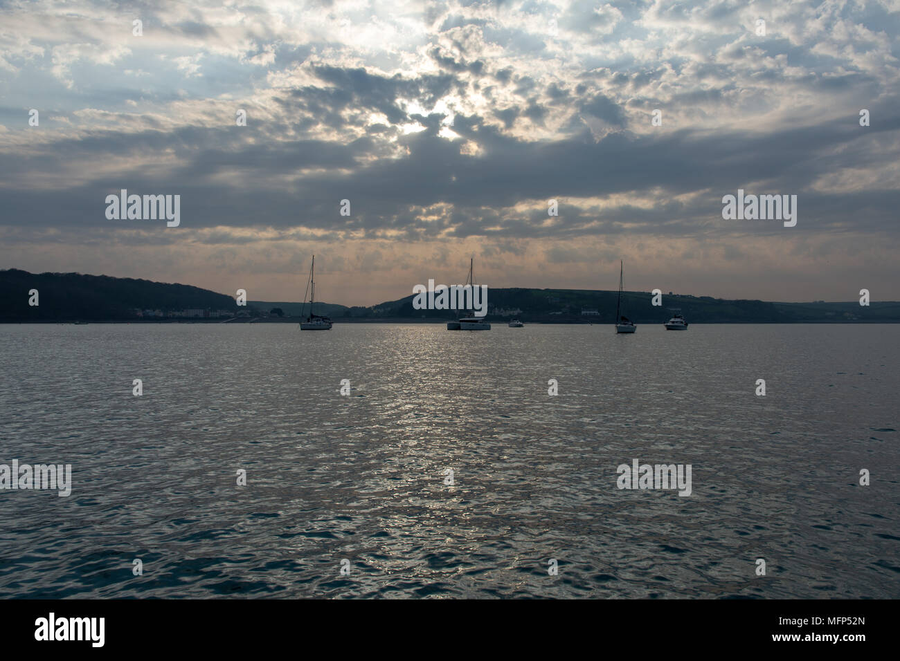 Sailing yachts and motor boats anchored at Dale Pembrokeshire on a spring evening Stock Photo