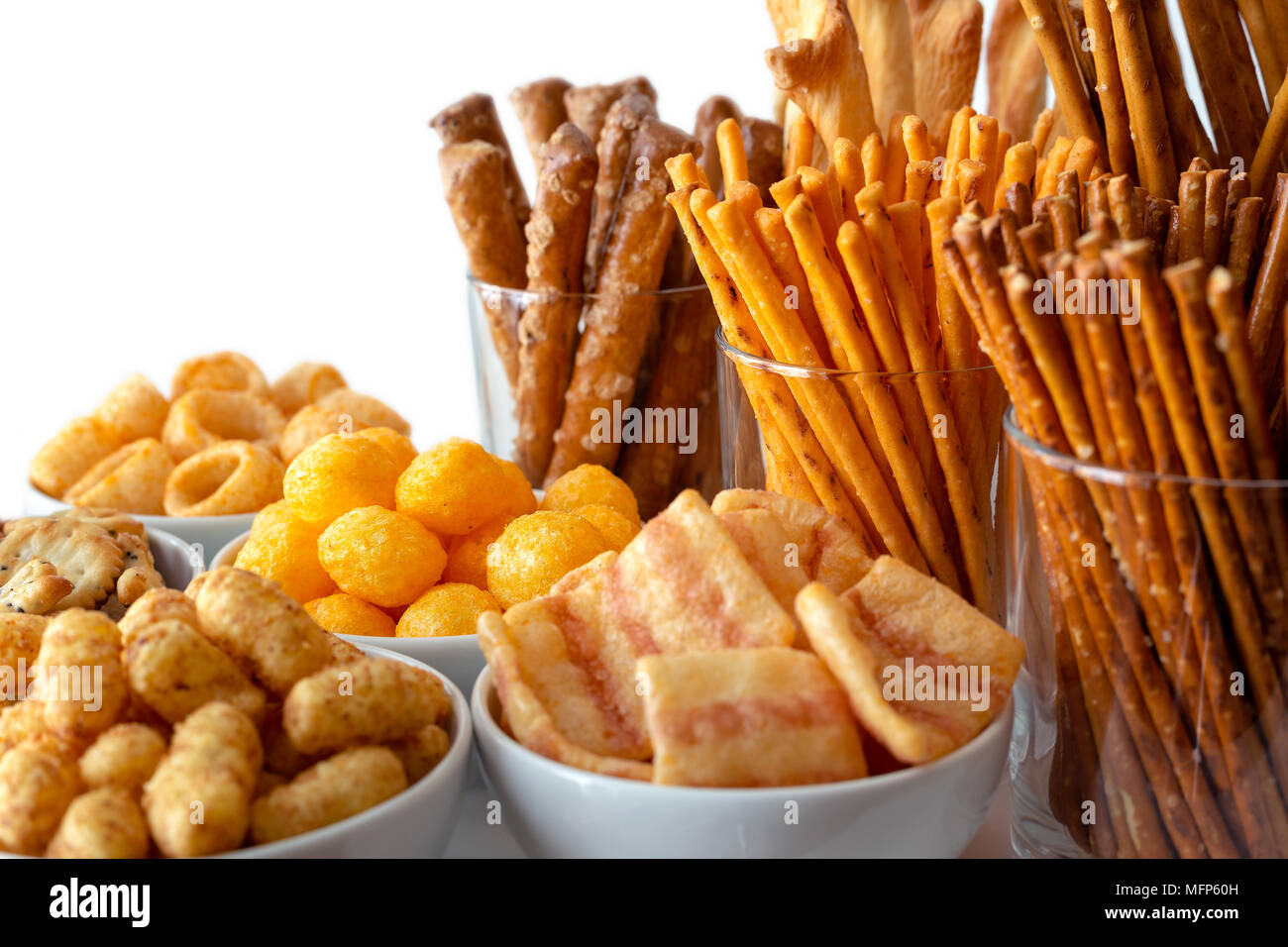 Selection of many types of savory snacks in white ceramic dishes and glasses. Stock Photo