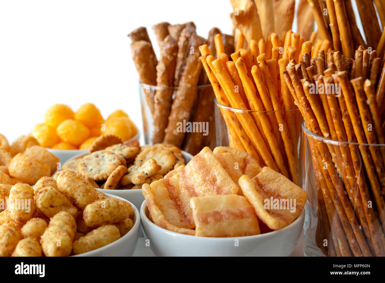 Selection of many types of savory snacks in white ceramic dishes and glasses. Stock Photo