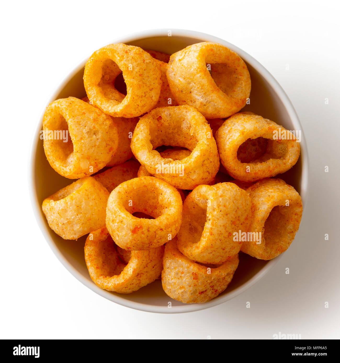 Extruded ring puff corn snack in white ceramic dish isolated on white