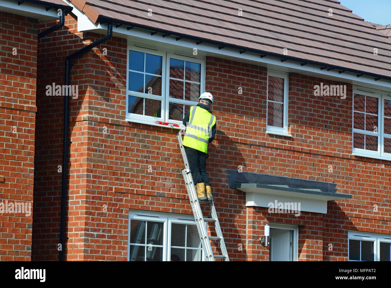 construction worker working on windows on buiding site of new build homes selby yorkshire united kingdom Stock Photo
