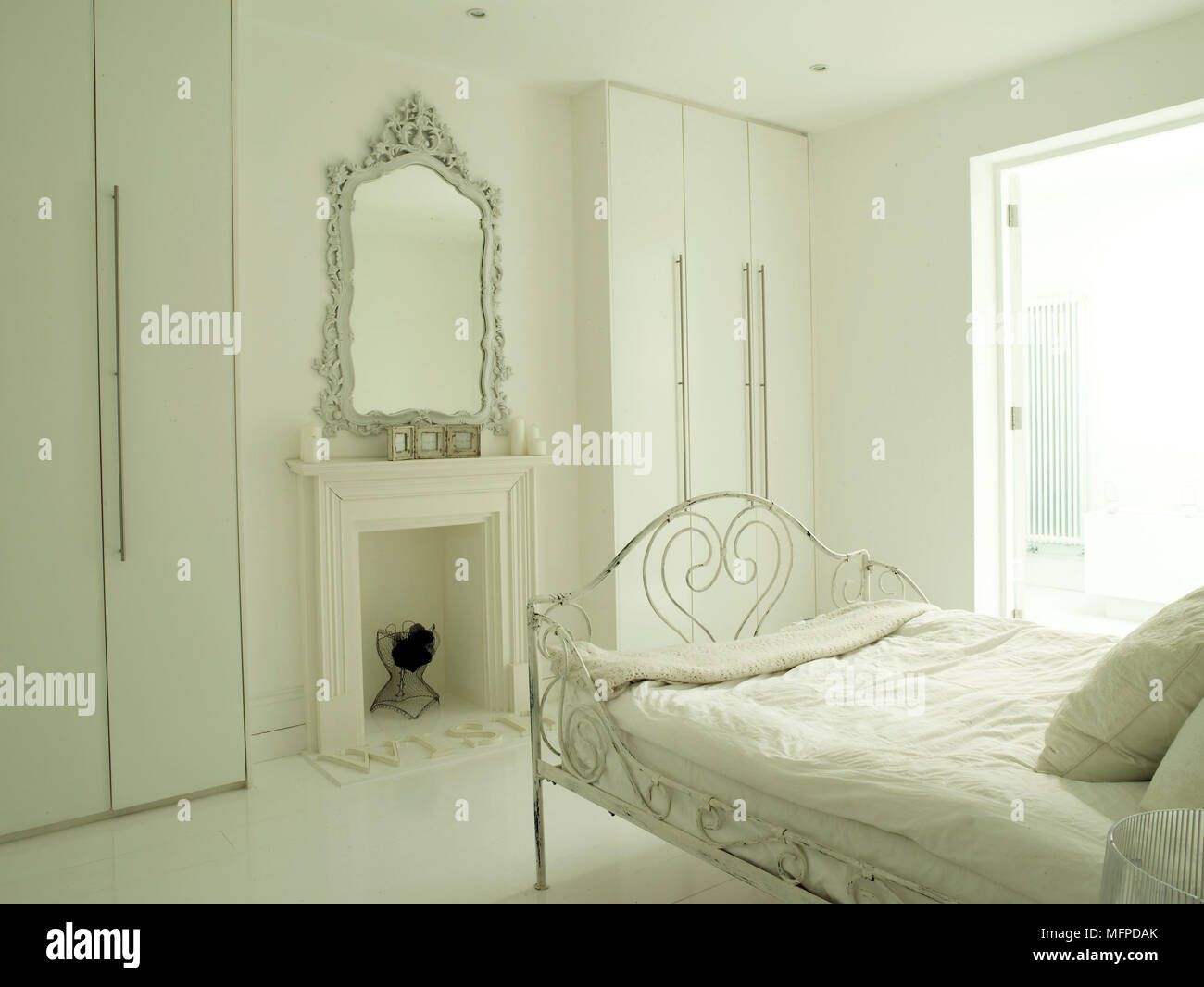 Wrought Iron Bed Facing Ornate Mirror Above Fireplace With Built