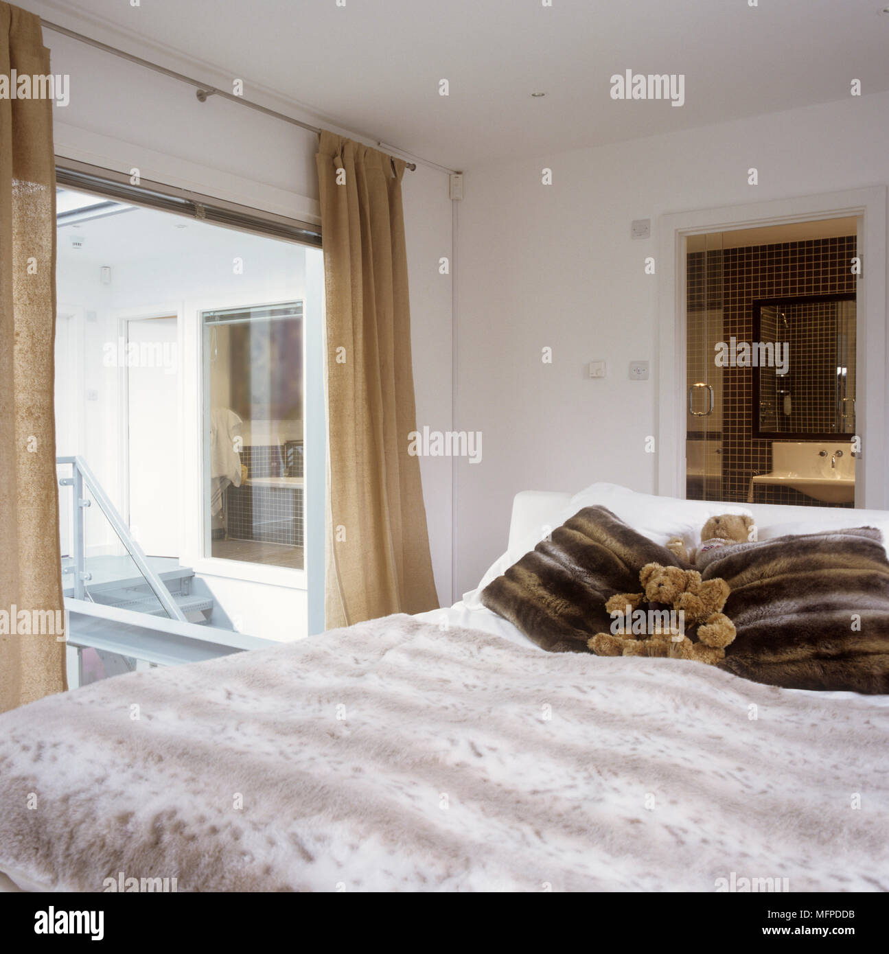 White Bedroom With Gold Curtains And Double Bed Stock Photo
