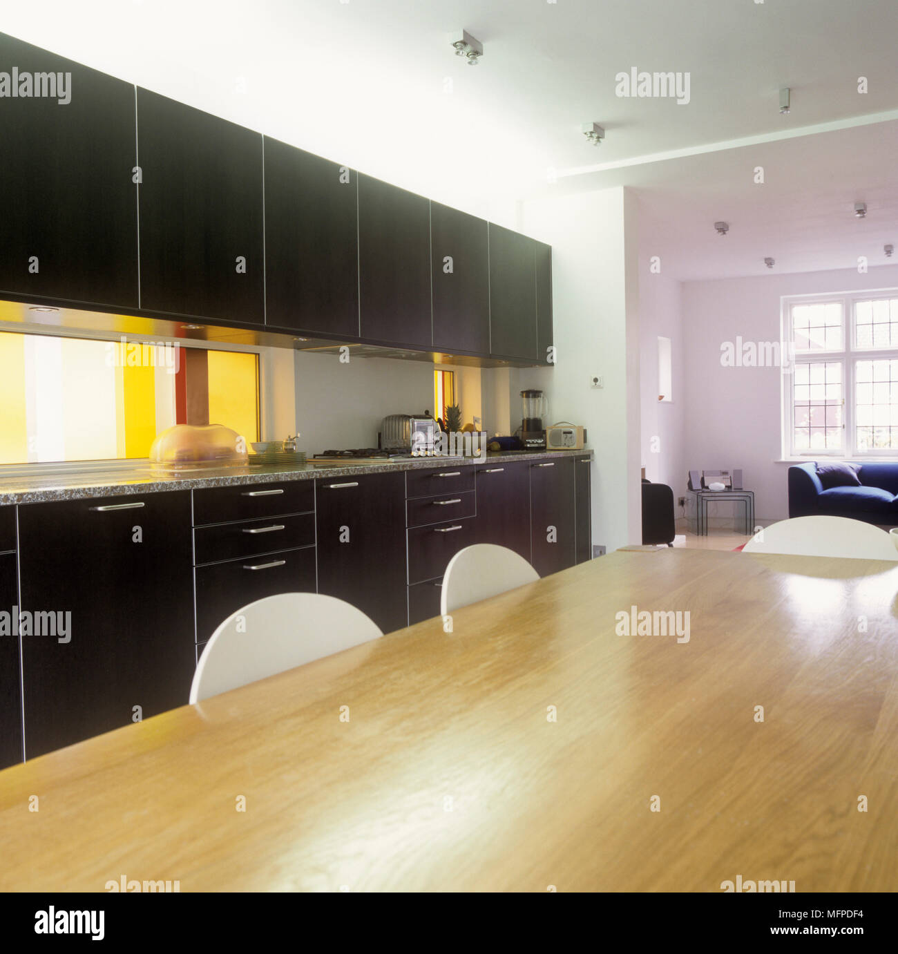 Kitchen with black units and wooden table Stock Photo - Alamy