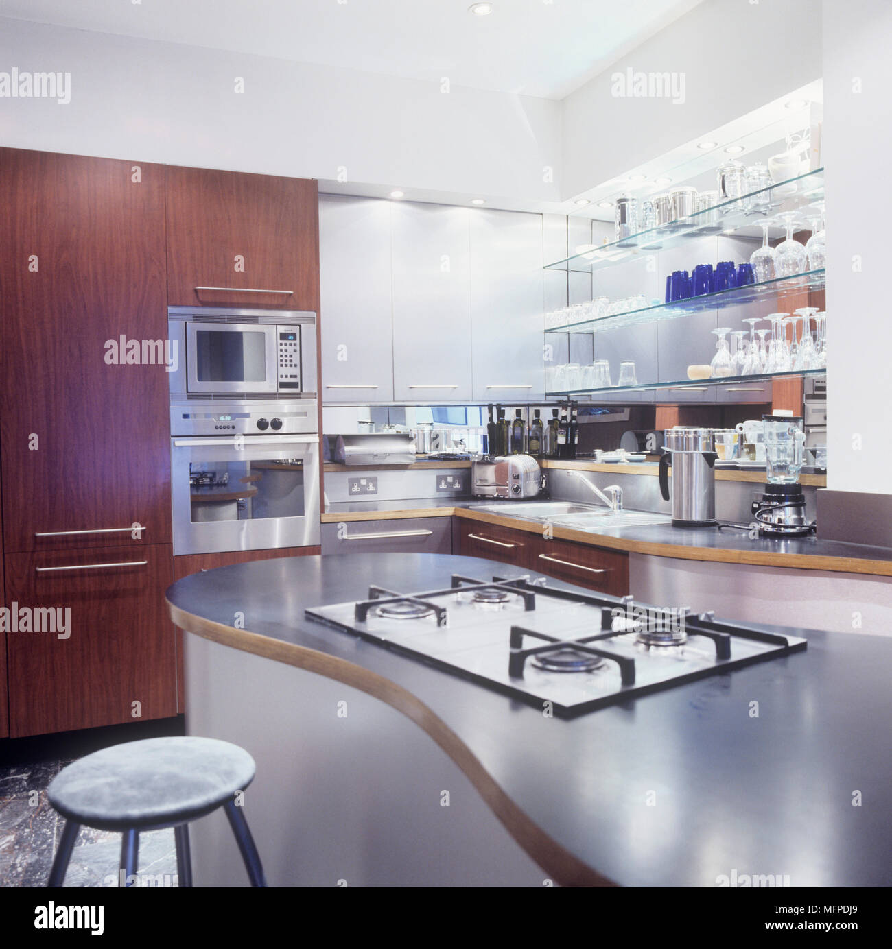 Kitchen central unit with set in gas hob and integral ovens Stock Photo