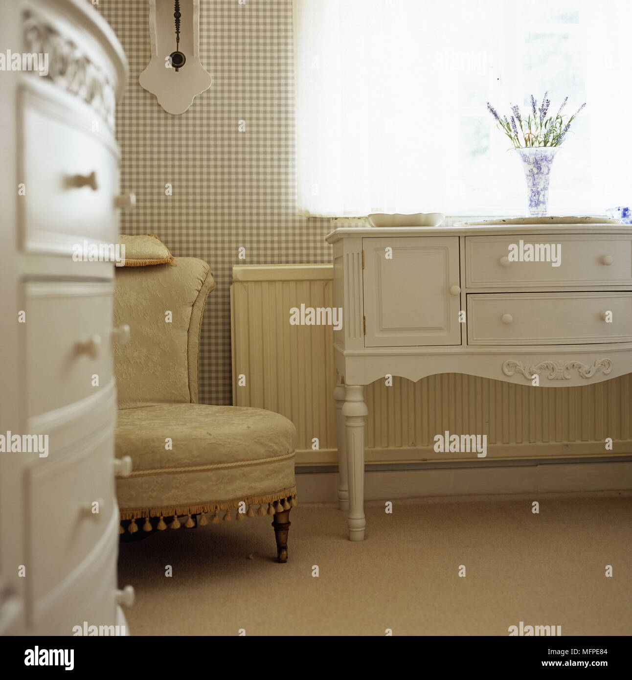 A Traditional Bedroom Detail White Dresser With A Vase Of