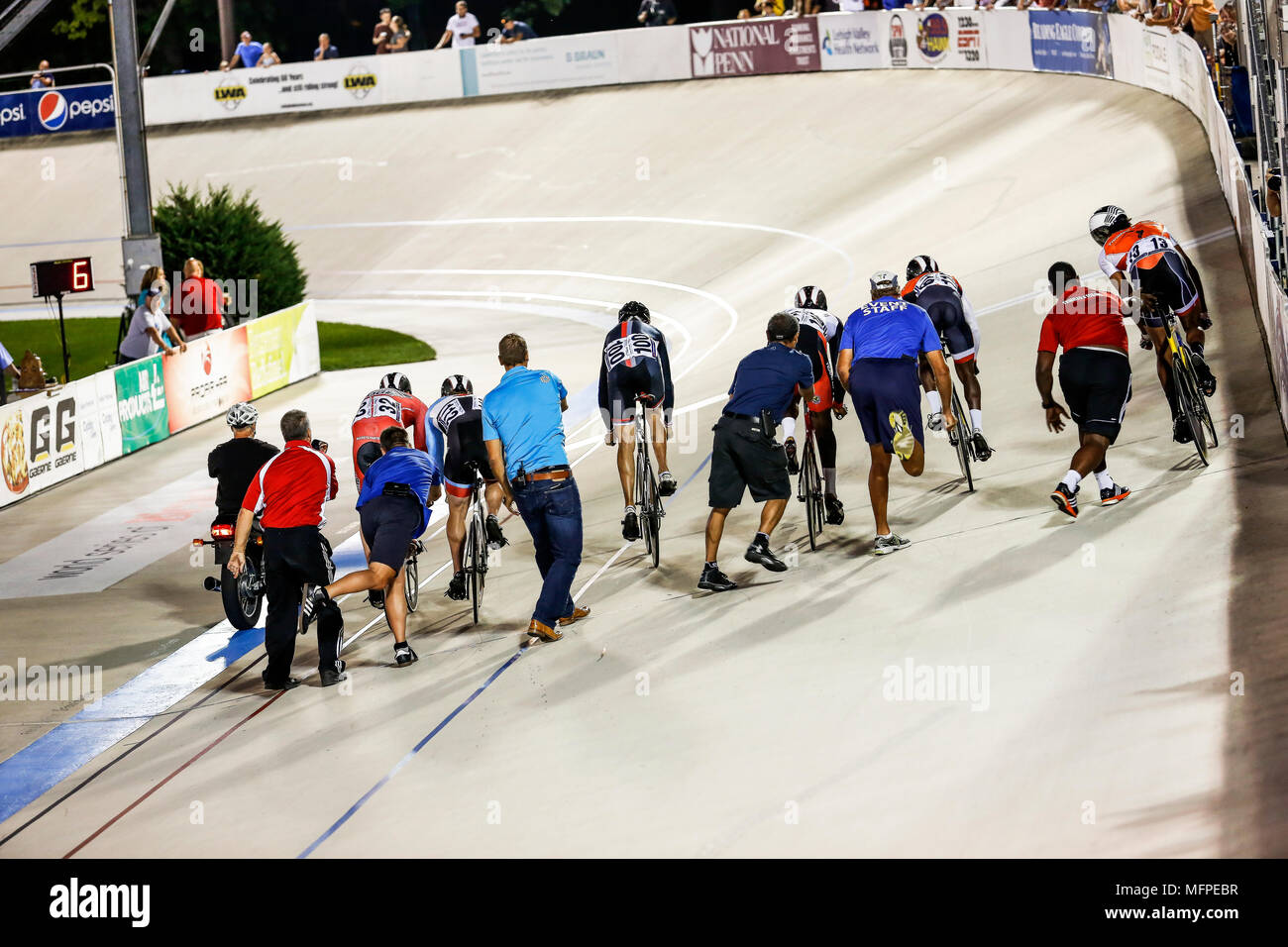 Seen from behind, the crazy contortions of those launching the racers of a Keirin bicycle race, T-Town Cycling Center, Pennsylvania. Stock Photo