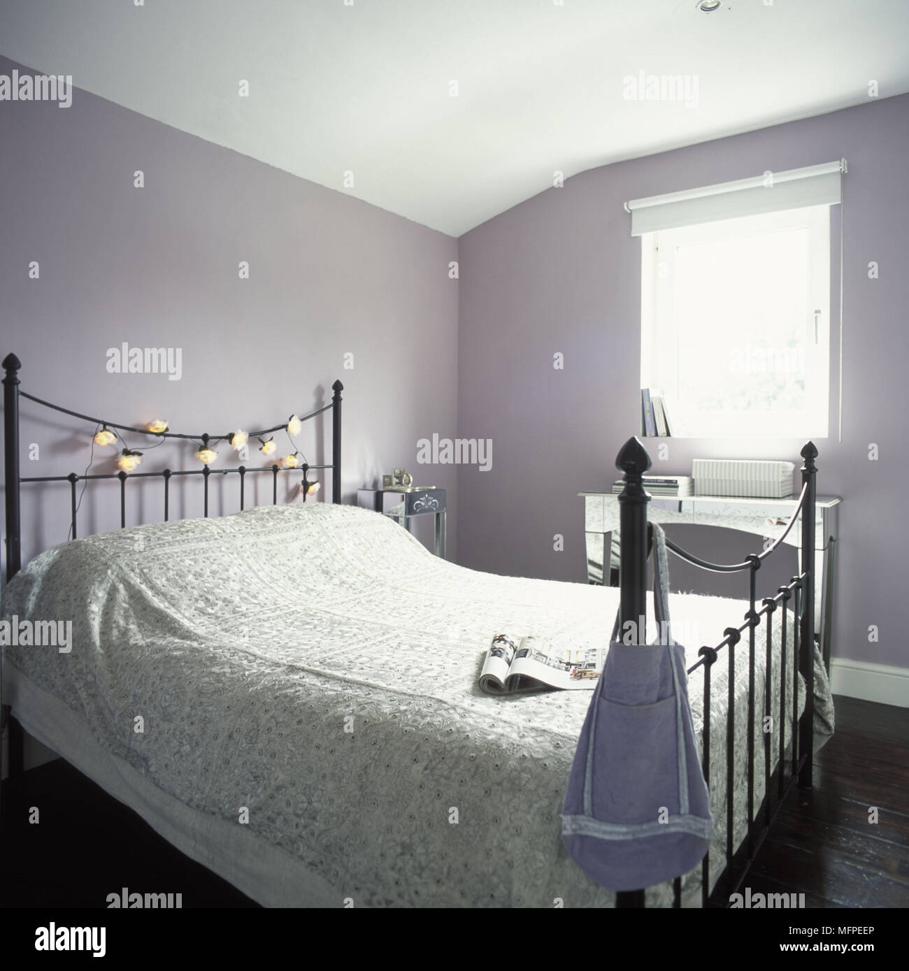 Iron double bed with fairy lights wrapped around the metal frame Stock  Photo - Alamy
