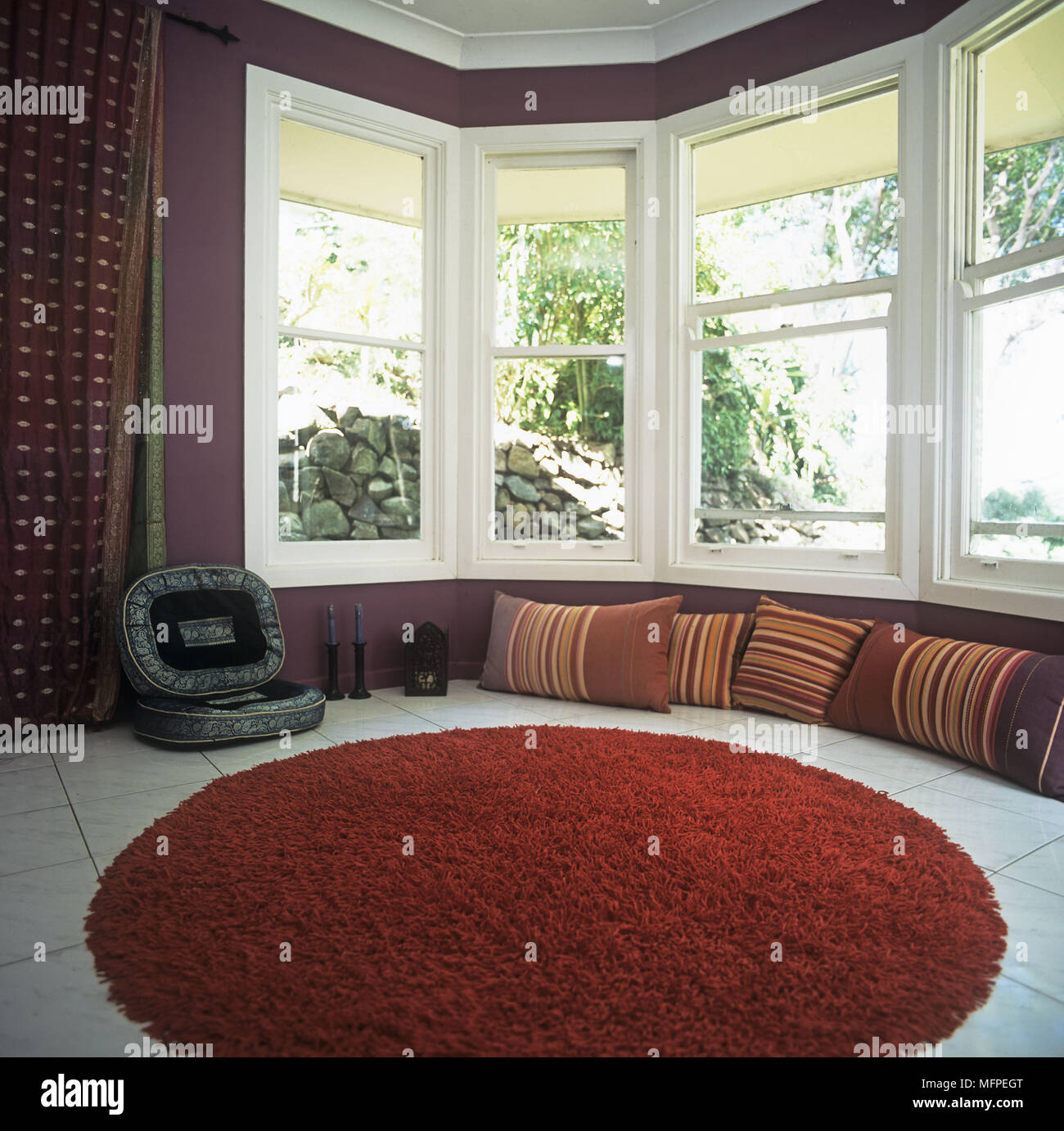 Modern sitting room detail red woollen rug and pillows by window Stock Photo