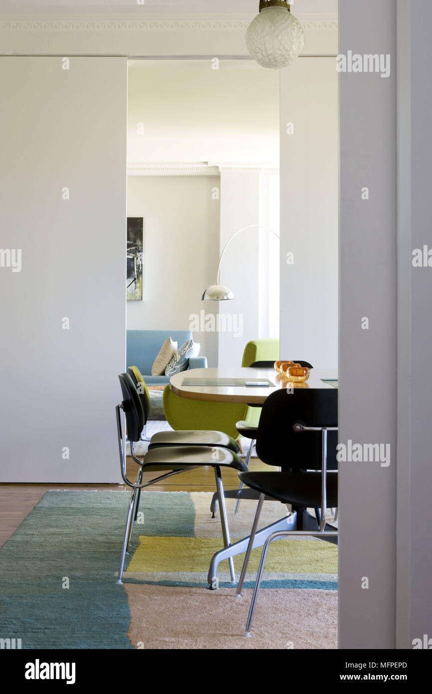 Black Chairs At Wooden Table In Modern Dining Room With Sliding Doors Giving View To Sitting Black Chairs At Wooden Table In Modern Dining Room With Sliding Doors Giving View To Sitting