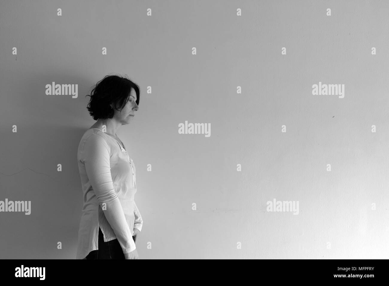 woman who is sad standing and slammed into the wall Stock Photo Alamy