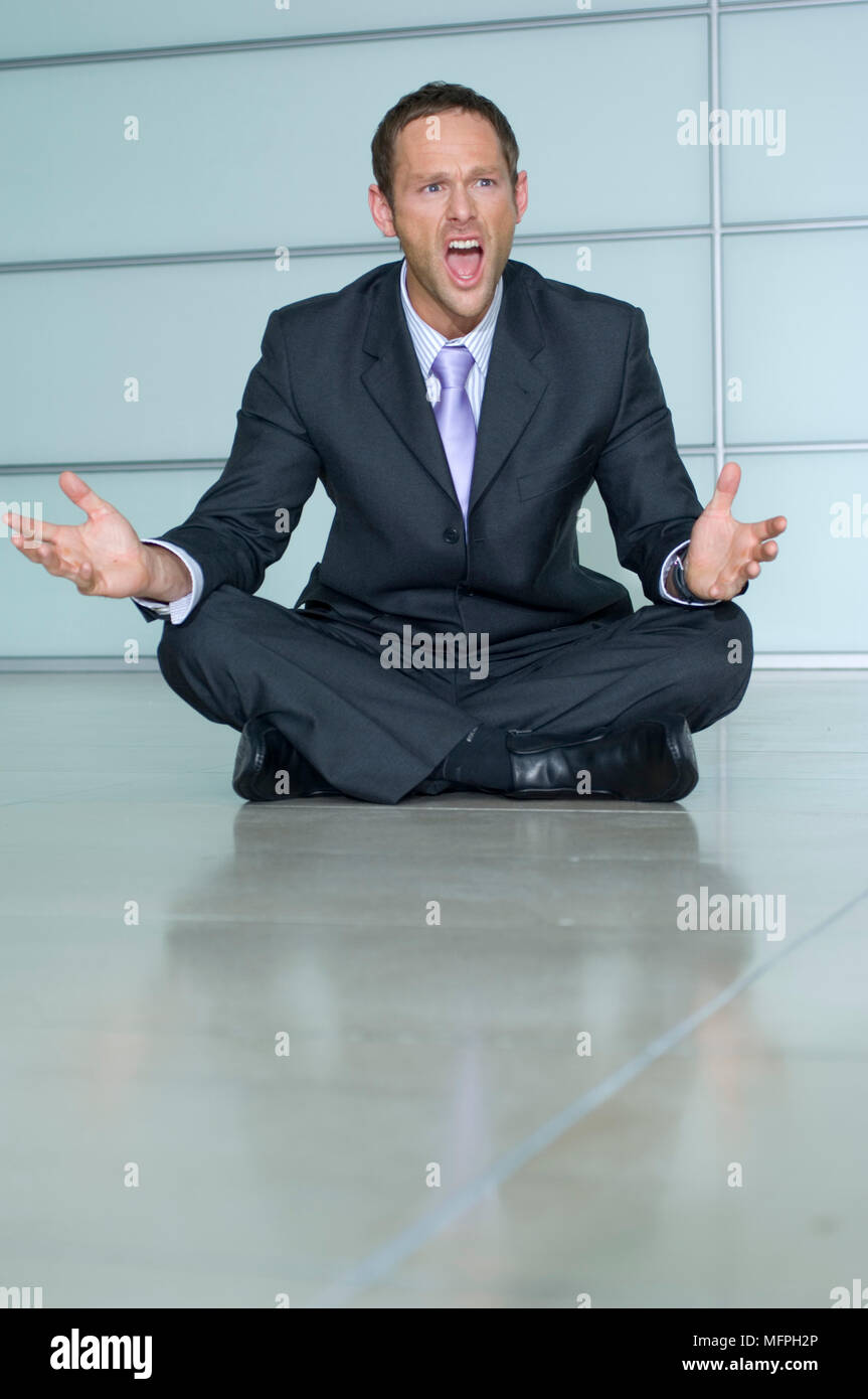 Businessman sitting on the floor and shouting   Ref: CRUSC 10020 102  Compulsory Credit: Staurt Cox / Photoshot Stock Photo