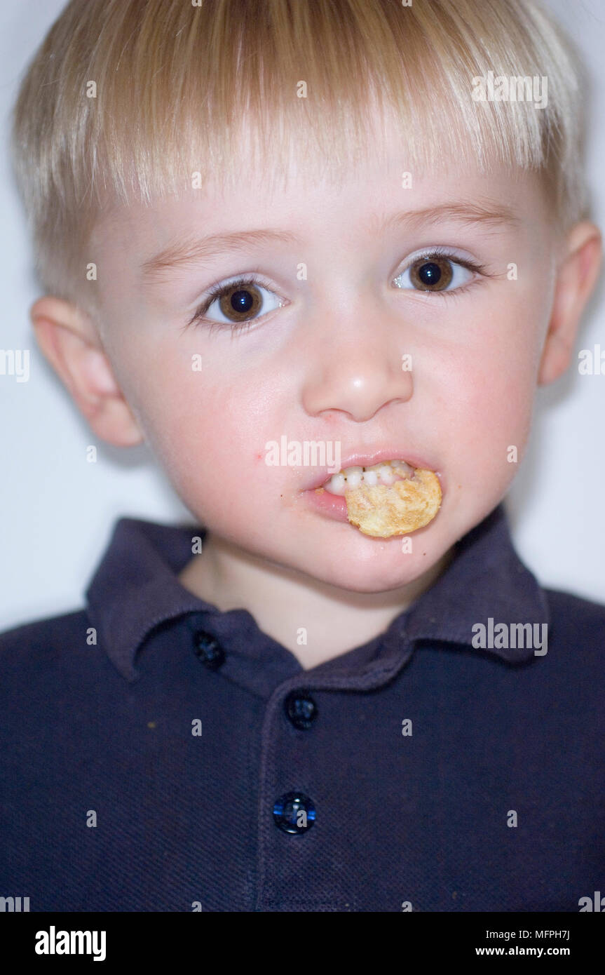 Portrait of a boy eating chips or crisps   Ref: CRUSC 10032 039  Compulsory Credit: Stuart Cox/ Photoshot Stock Photo