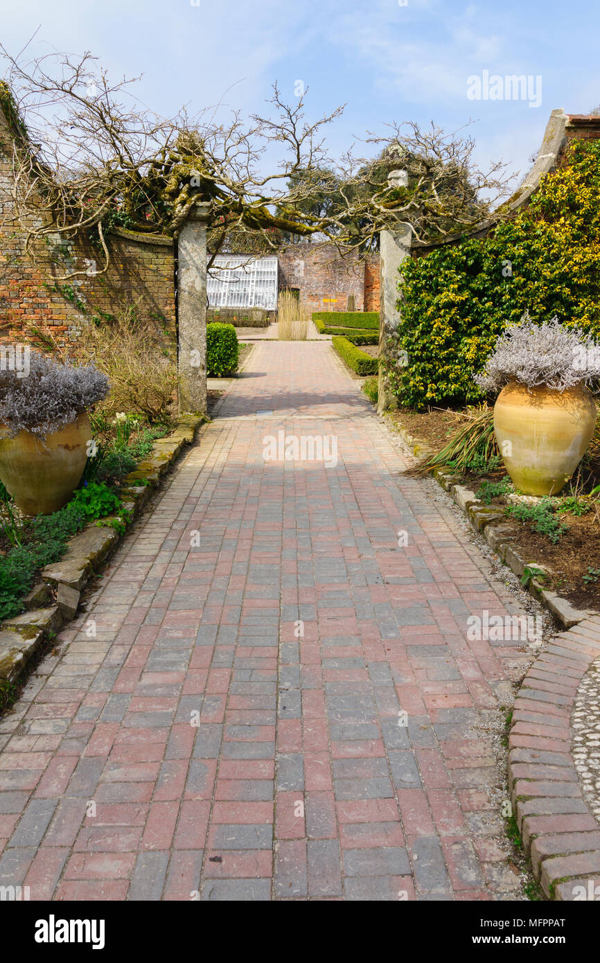 Brick paved path and archway leading from the sundial garden to the flower garden and citrus greenhouse in the Lost Gardens of Heligan Cornwall Stock Photo