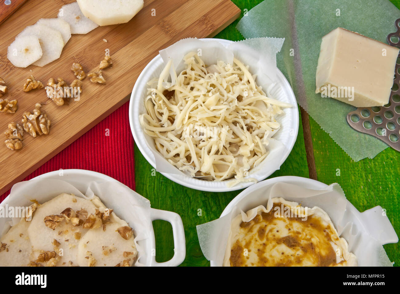 Fig mustard, pears and walnuts be given on puff pastry and covered with shredded Vacherin. Stock Photo