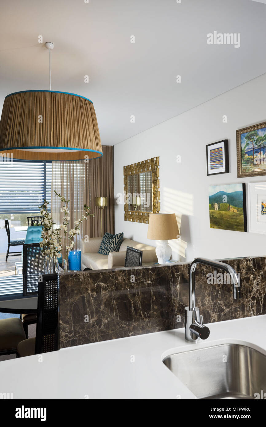 Chrome tap fitting over sink set in worktop in kitchen in modern open