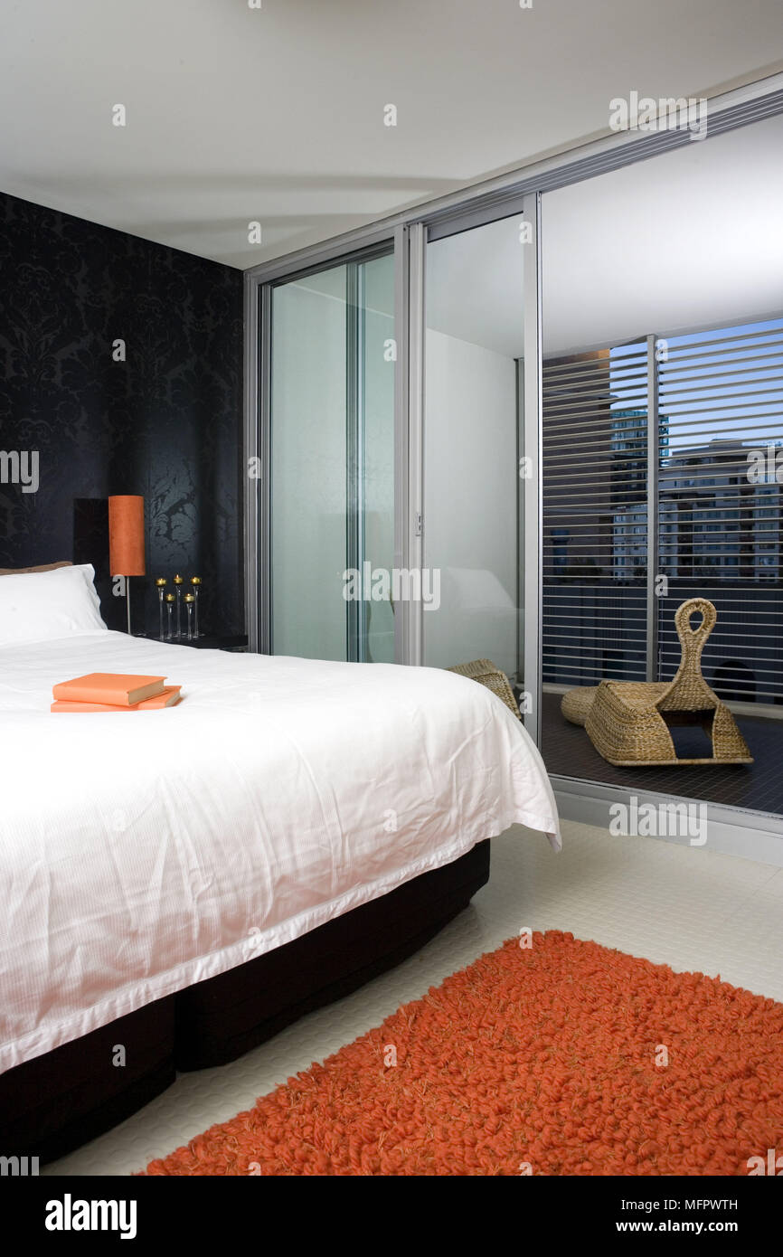 Double Bed In Modern Bedroom With Glass Doors To Terrace