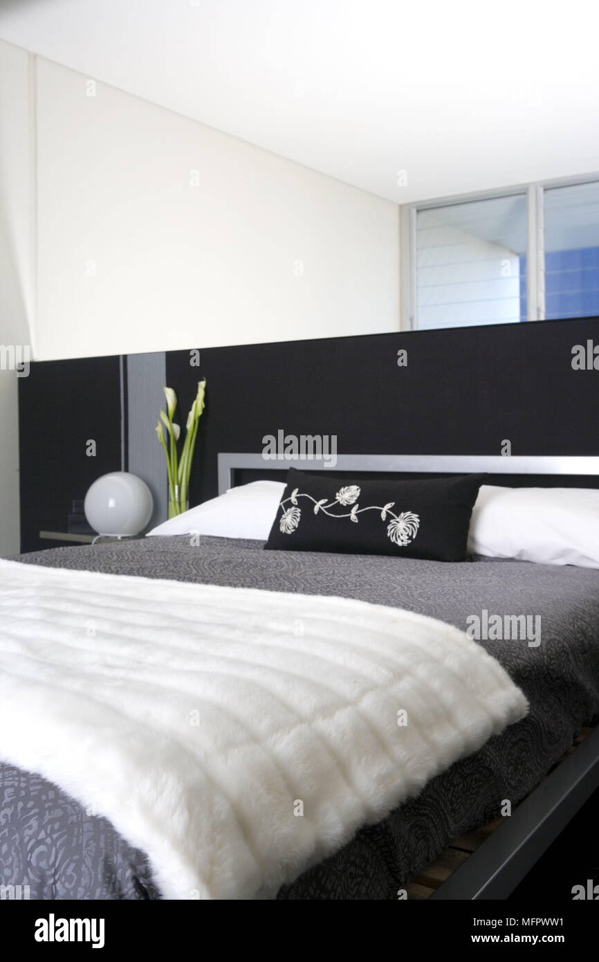 Double bed with partition wall as headboard in modern bedroom Stock