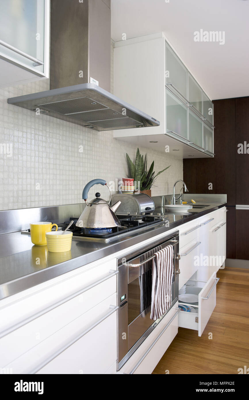 Gas hob set in worktop in modern kitchen with white units Stock Photo