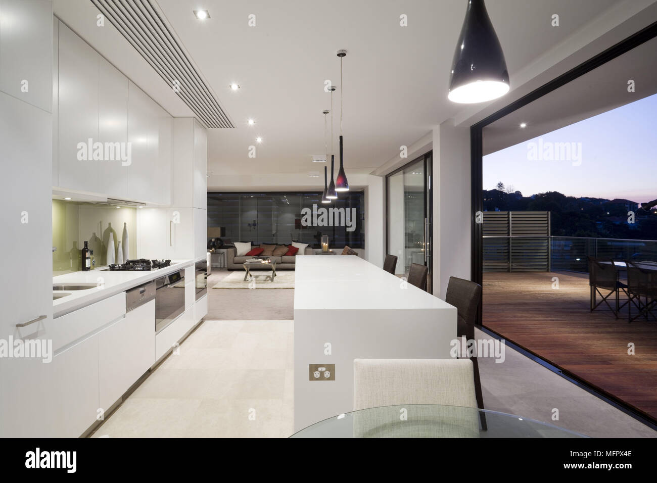 Lights suspended above central island unit in modern kitchen Stock