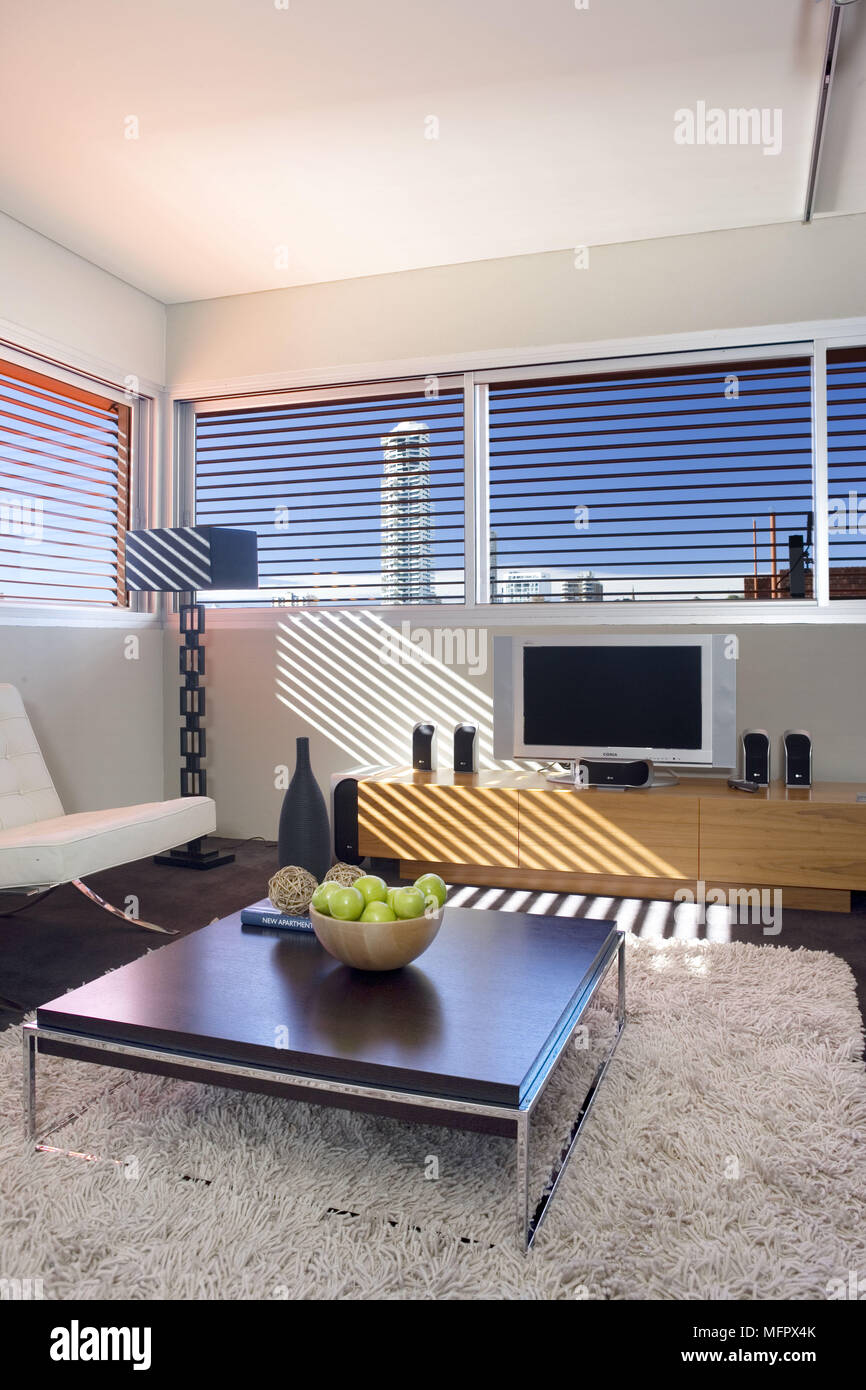 Low coffee table in front of television on cabinet in modern