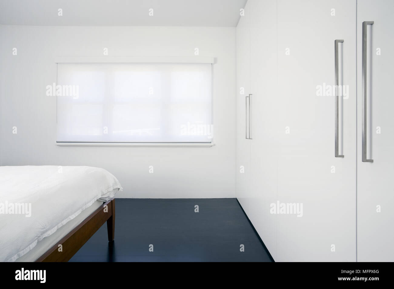 Modern White Bedroom With Built In Wardrobes Stock Photo