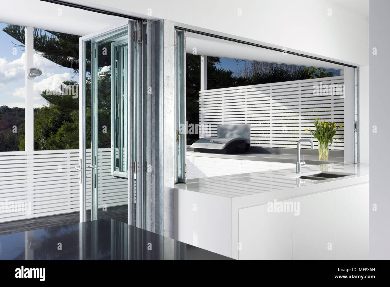 Modern white kitchen with concertina door to balcony terrace Stock Photo Alamy