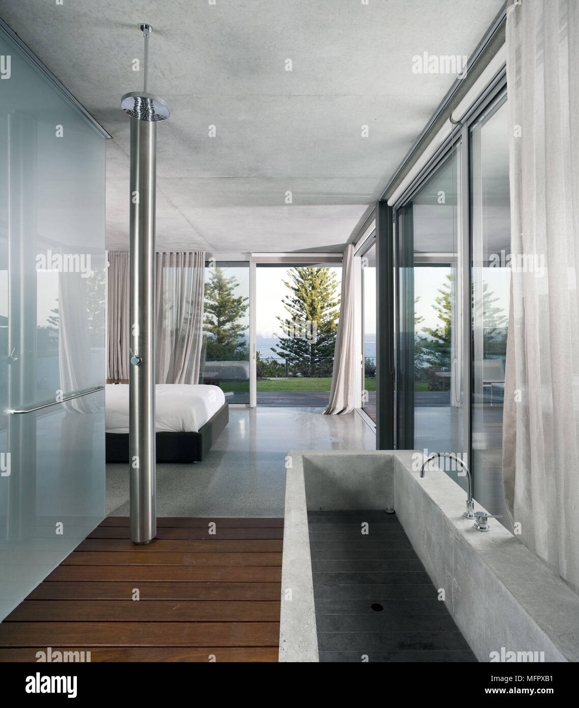 Stone freestanding bathtub in modern bathroom with opaque glass