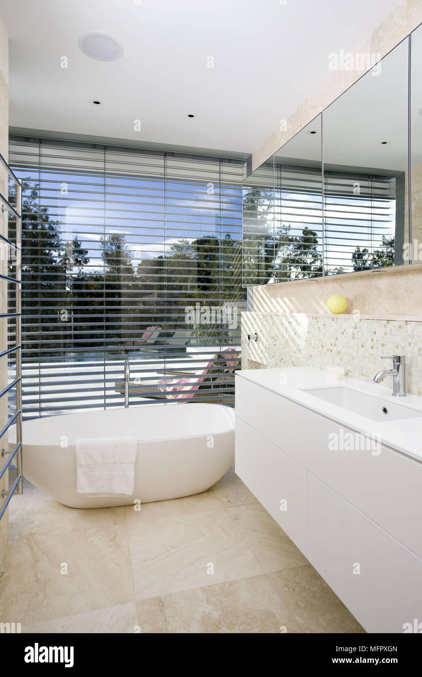 Washbasin set in unit next to freestanding bathtub in modern bathroom ...