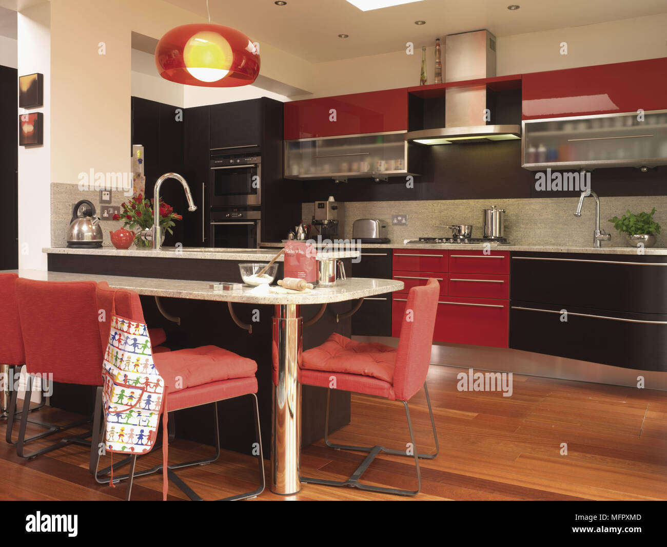Contemporary red kitchen with central breakfast bar Stock Photo - Alamy