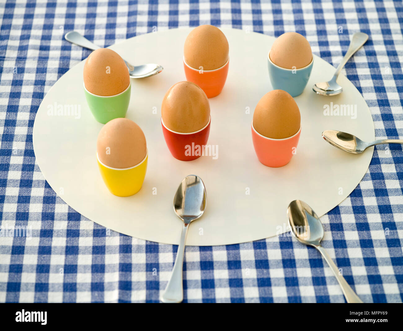Boiled eggs in colourful egg cups Stock Photo