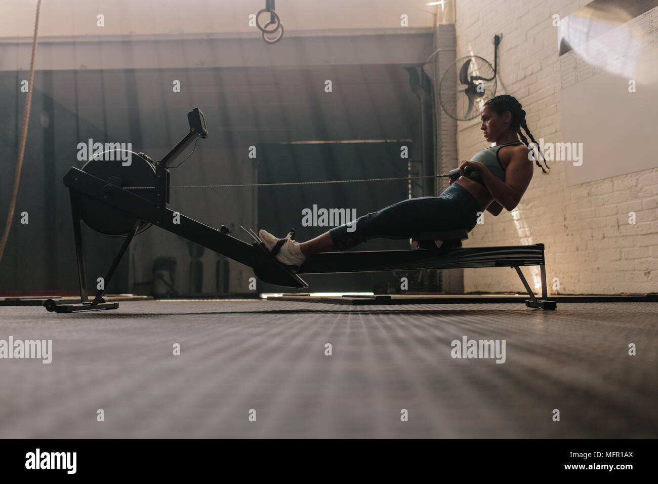Female using rowing machine at health club. Healthy woman doing ...