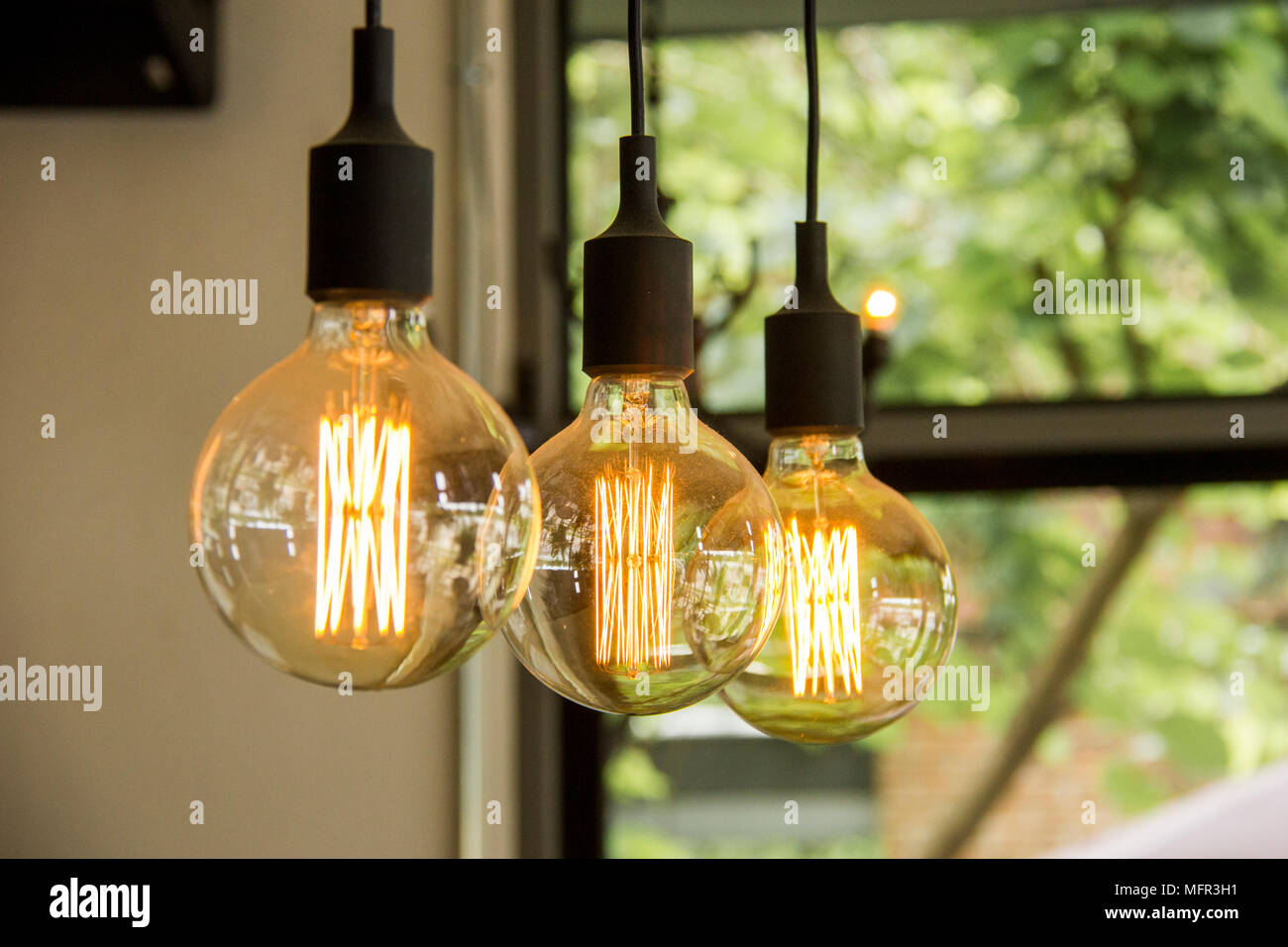 Glowing retro light bulbs hanging from ceiling Stock Photo Alamy