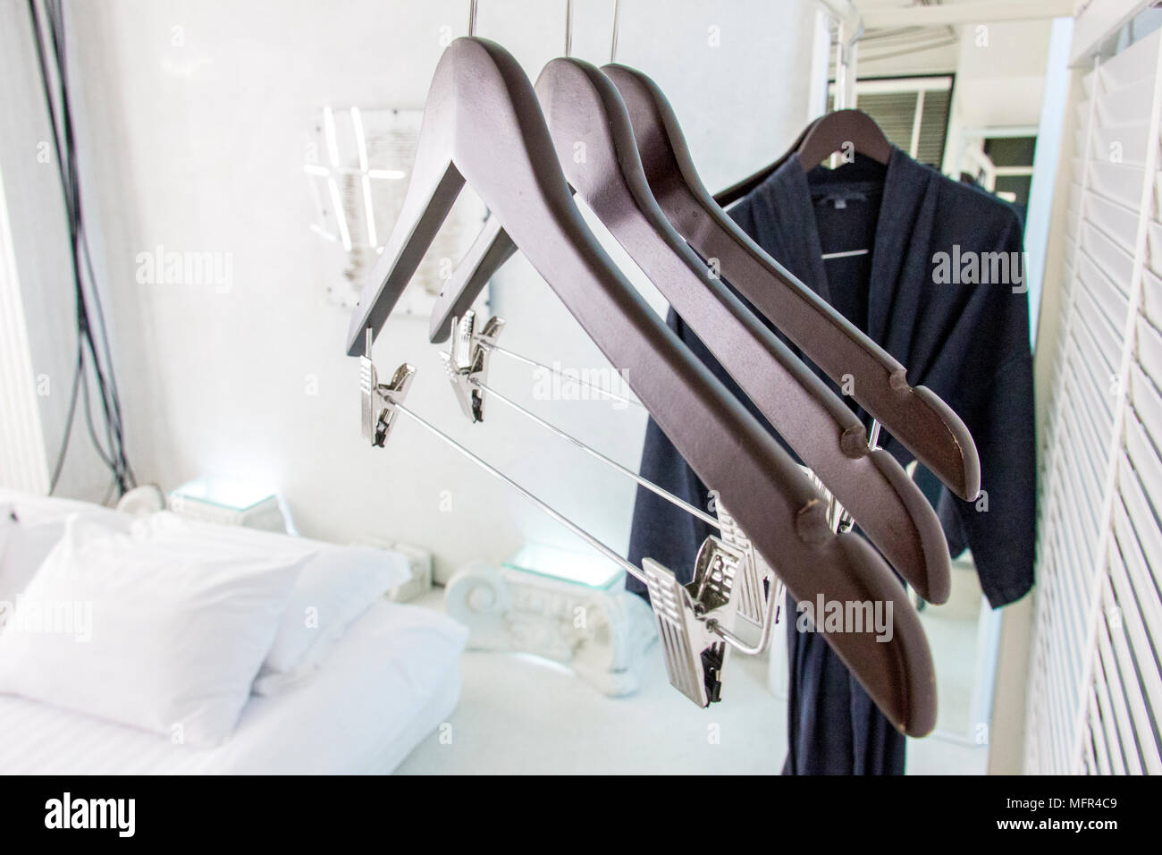Wooden cloth hangers on clothes rail and bathrobe Stock Photo - Alamy