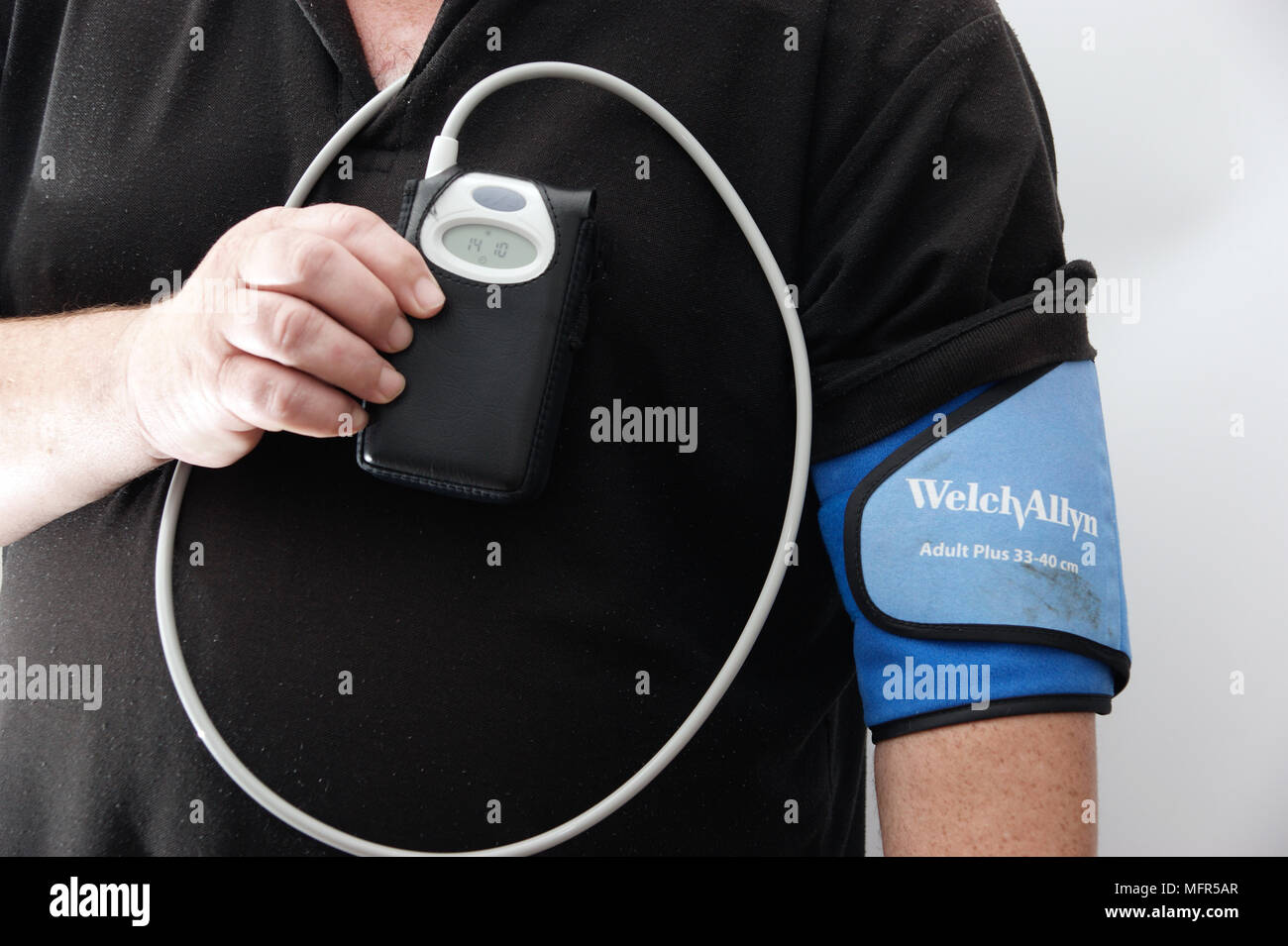 24 hour blood pressure monitoring unit taking readings every half an hour  on a middle aged man model release Stock Photo - Alamy