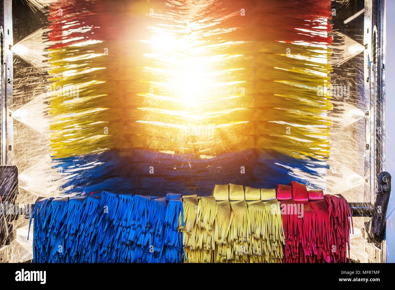 Sunny Automatic Car Wash. Spinning Colorful Brushes and the Sun in the