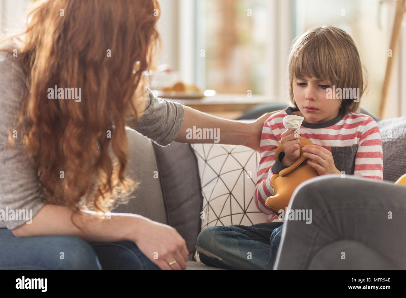 Caring mother supporting her sick son staying at home with a cold Stock Photo